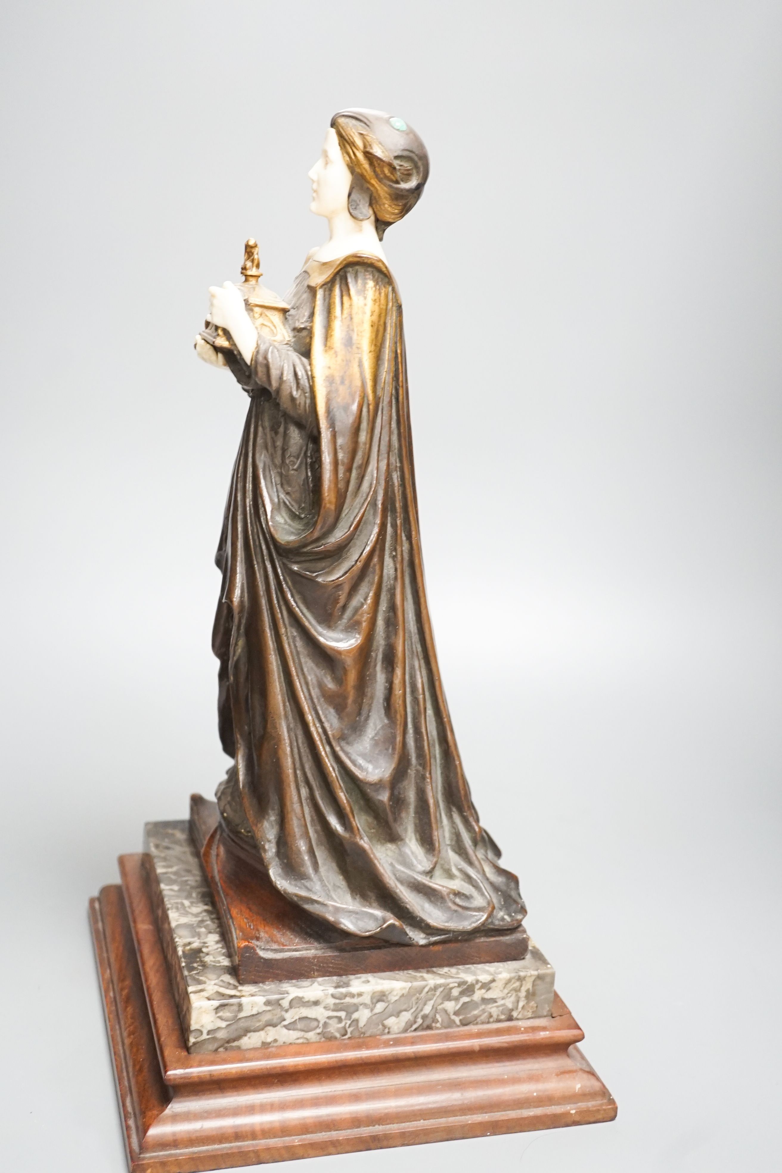 A German Art Nouveau bronze and ivory figure of Pandora, with inset carved ivory head and hands on polished stone and cut wood base, signed F. Jahn, 41cm high